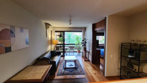 a living room with a couch and a table at Lorena Residence - Cozy Flat with Balcony in São Paulo