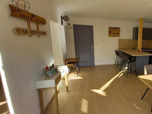 a living room with a table and a piano at Gite famille & bain nordique, Chez Bubu, école rénovée au cœur des Vosges in Vecoux