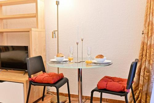 une salle à manger avec une table et deux chaises dans l'établissement Élégant et bien situé votre havre de paix à Paris, à Paris