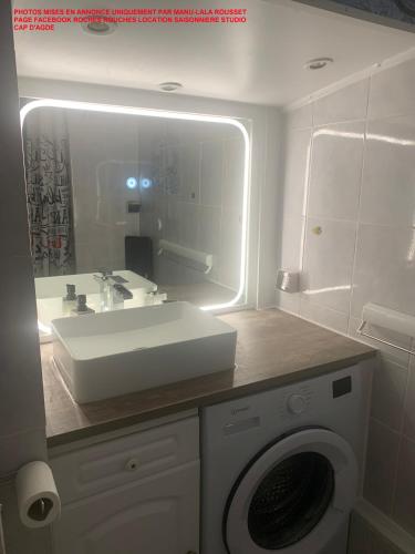 une salle de bain avec un lavabo et une machine à laver dans l'établissement Studio 200m plage du môle vue mer, au Cap d'Agde