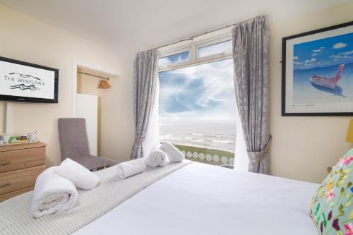 a bedroom with a bed and a window with the ocean at The Wheeldale in Whitby