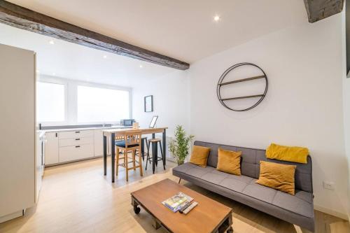 un salon avec un canapé et une table dans l'établissement Biau - Séjour à Auxerre, à Auxerre