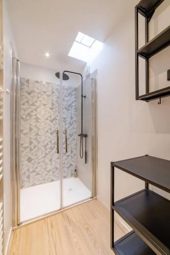 une salle de bain avec une douche avec une porte vitrée dans l'établissement Biau - Séjour à Auxerre, à Auxerre