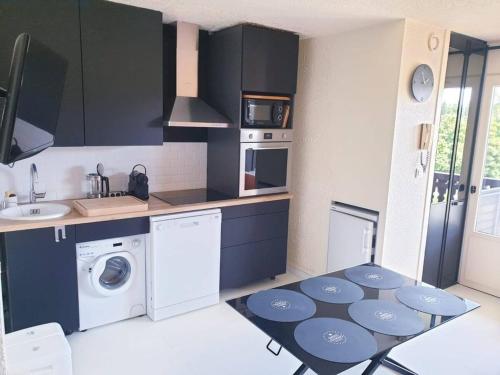 Il comprend une cuisine équipée d'un lave-linge, d'un sèche-linge et d'un évier. dans l'établissement Mazots - Séjour aux Carroz, aux Carroz d'Arâches