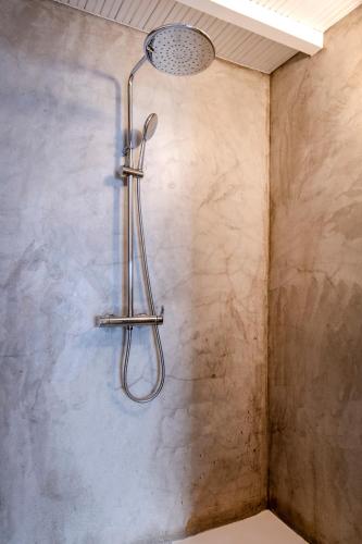 a shower with a shower head in a bathroom at Villa Infinium TWO, Sunset views 10' from Mykonos town! in Agios Stefanos