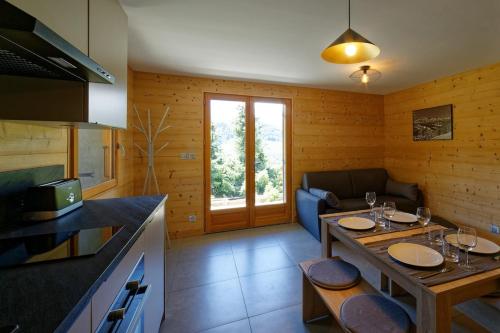 - une cuisine et un salon avec une table et des verres dans l'établissement Logement 3 étoiles avec vue imprenable sur les montagnes, ski bus, à Manigod