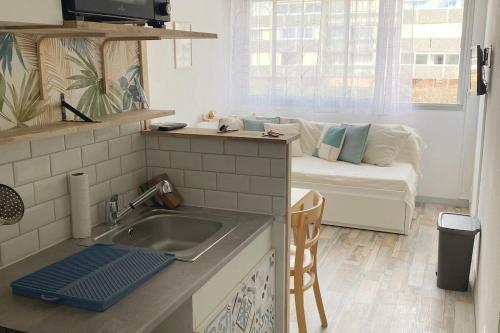 Il dispose d'une cuisine avec un évier et d'un salon avec un canapé. dans l'établissement Appartements parfaits pour Cures Thermales, au bord de l’Etang de Thau, à Balaruc-les-Bains