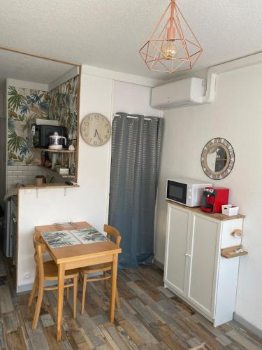 une petite cuisine avec une petite table et une petite cuisine avec une petite table dans l'établissement Appartements parfaits pour Cures Thermales, au bord de l’Etang de Thau, à Balaruc-les-Bains