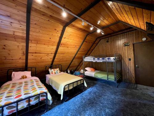 a room with two beds in a wooden cabin at Groovy Cabin in the Woods in Pollock Pines