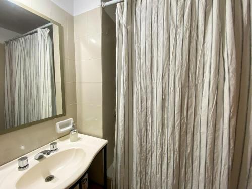 a bathroom with a shower curtain and a sink at Ideal para compartir en familia o con amigos in San Salvador de Jujuy