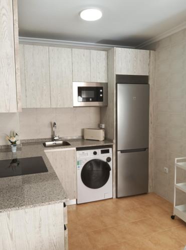 a kitchen with a refrigerator and a dishwasher at Monte Dobra in Los Corrales de Buelna
