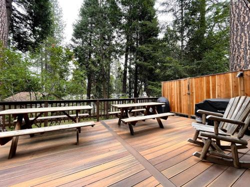 a deck with benches and picnic tables on it at Groovy Cabin in the Woods in Pollock Pines