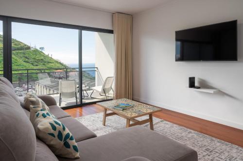 a living room with a couch and a television at Amparo II by An Island Apart in Funchal