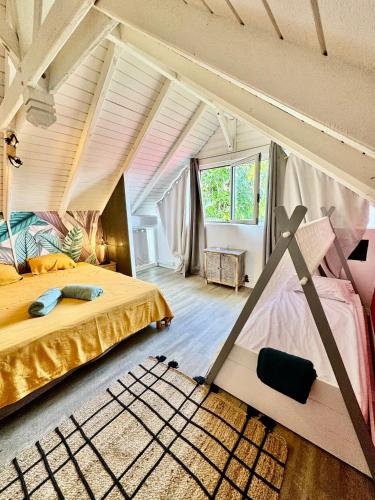 a bedroom with two beds in a room with aamed ceilings at Auberge de jeunesse El Poyito Kite & Surf Camp in Sainte-Anne