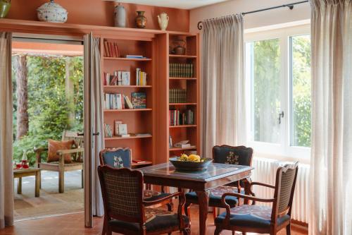 a dining room with a table and chairs and a book shelf at Hotel Eden Roc - The Leading Hotels of the World in Ascona