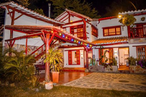 a white house with christmas lights on it at Casa Aminta in Curití