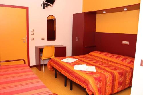 a bedroom with a bed and a desk and a table at Meublé Nautic Rooms b&b in Cesenatico