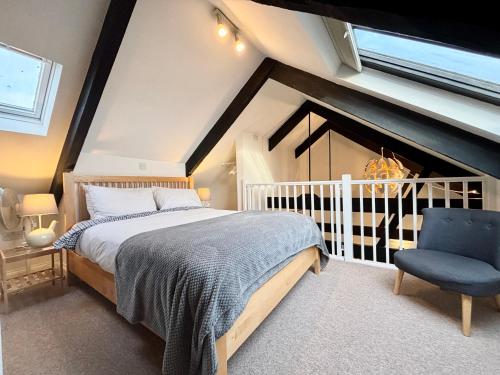 a bedroom with a bed and a blue chair at Harbourside apartment with seaviews and parking in Penzance