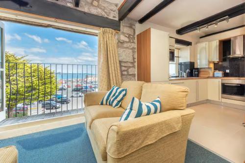 a living room with a couch and a large window at Harbourside apartment with seaviews and parking in Penzance