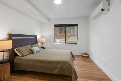 a bedroom with a bed and a window at Modern Condo with Incredible Mountain Backdrop 207 in Juneau