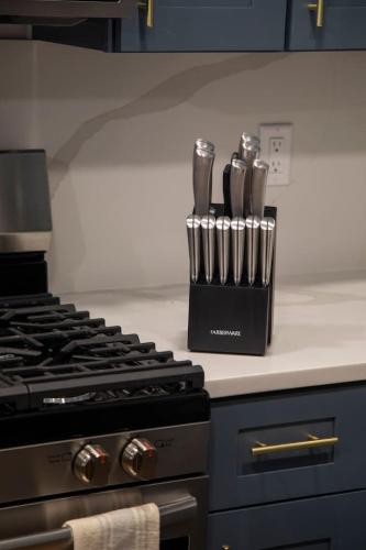a kitchen counter with utensils in a knife block next to a stove at Modern Condo with Incredible Mountain Backdrop 207 in Juneau
