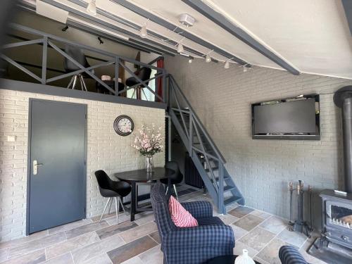 a living room with a table and a tv on a wall at heerlijk-huisje in Zandschel