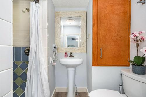 un bagno con lavandino, WC e specchio di Cozy Cottage Pool Home close to Beaches a Melbourne
