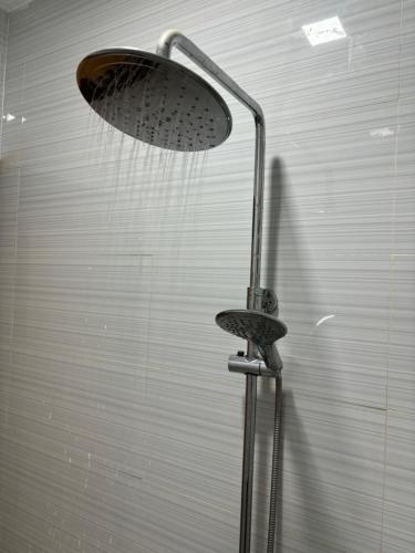 a shower with a shower head in a bathroom at Heritage Haven Guesthouse in Vigan