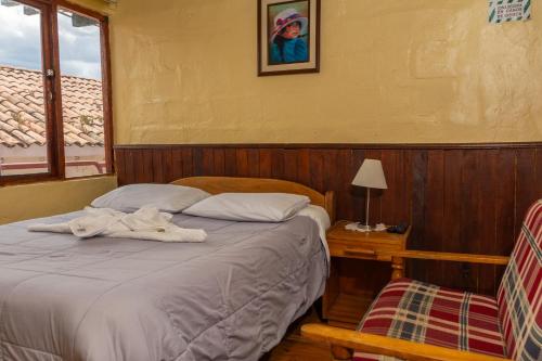 a bedroom with a bed with a towel on it at Samay Wasi Hostel in Cusco