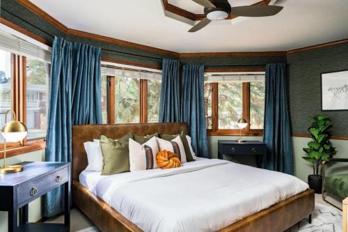 a bedroom with a large bed with blue curtains at The Luxe Retreat With A Pool And A Game Room in Arvada