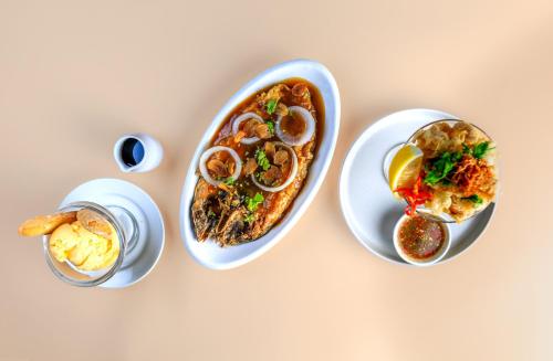 a table with three plates of food and a drink at Holiday Inn & Suites Batangas LimaPark by IHG in Batangas City