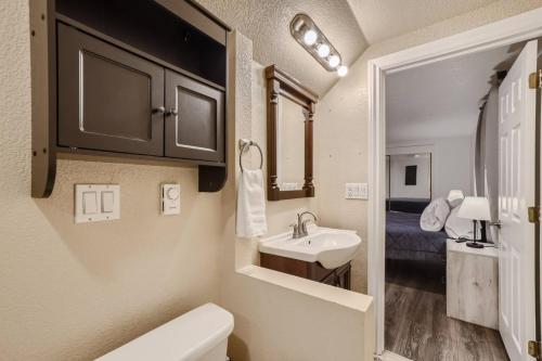 Un baño pequeño con lavabo e inodoro. en Guest Suite With A Pool A Hot Tub And A Fireplace In Arvada, en Arvada
