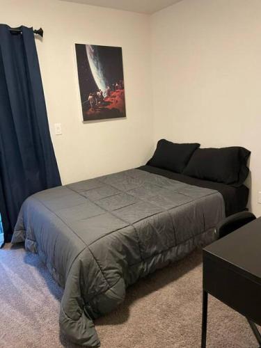 a bedroom with a bed and a picture on the wall at 3 Bedrooms 2 Bath Townhome In West Denver Near to Red Rocks And Foothills in Lakewood