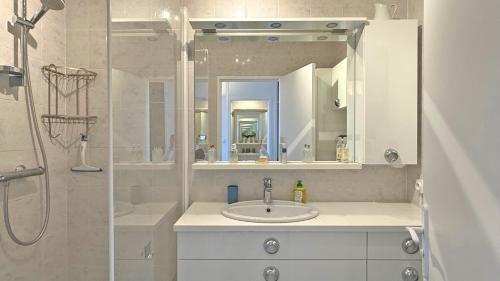 une salle de bain avec un lavabo et une douche avec un miroir dans l'établissement Le Maxime, à Sainte-Maxime