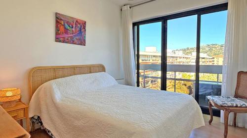 une chambre avec un lit et une grande fenêtre dans l'établissement Le Maxime, à Sainte-Maxime