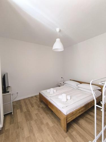 une chambre blanche avec un lit et une télévision dans l'établissement Segantini 48, à Arco