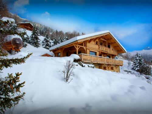 une cabane en rondins avec de la neige devant elle dans l'établissement La Grange à L'Ours - OVO Network, à Manigod