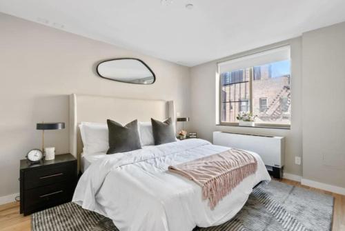 Un dormitorio con una cama blanca grande y una ventana en 3BR Penthouse with Massive Private Rooftop, en Nueva York