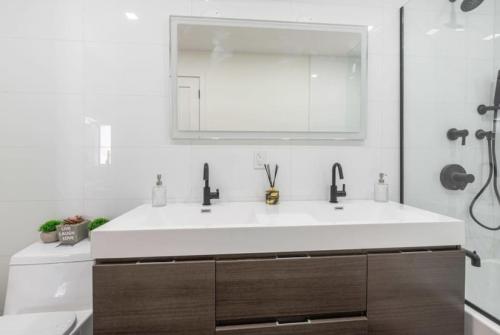 Un baño con un lavabo blanco y un espejo. en 3BR Penthouse with Massive Private Rooftop, en Nueva York