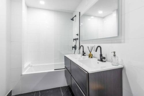 a white bathroom with a sink and a bath tub at 3BR Penthouse Suite with Massive Private Rooftop in New York