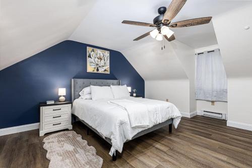 a bedroom with a blue accent wall and a ceiling fan at Serenity Inn in Ronks