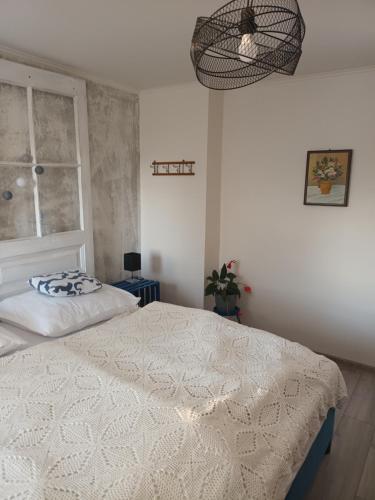 a bedroom with a white bed and a window at Villa Evetes in Jablonov nad Turnou