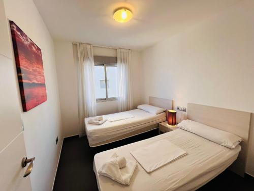 a room with two beds and a window at La Manga Beach Club Lateral by Alina365 in La Manga del Mar Menor