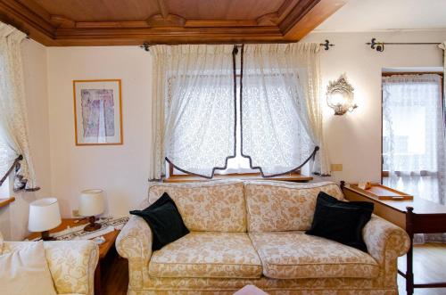 a living room with a couch and a window at Cà Enrosadira primo piano in San Vito di Cadore