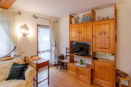 a living room with a couch and a tv at Cà Enrosadira primo piano in San Vito di Cadore