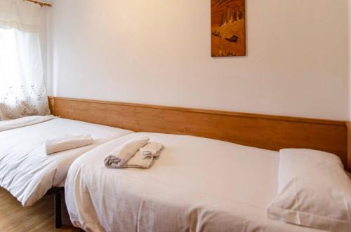 a bedroom with two beds with towels on them at Cà Enrosadira primo piano in San Vito di Cadore