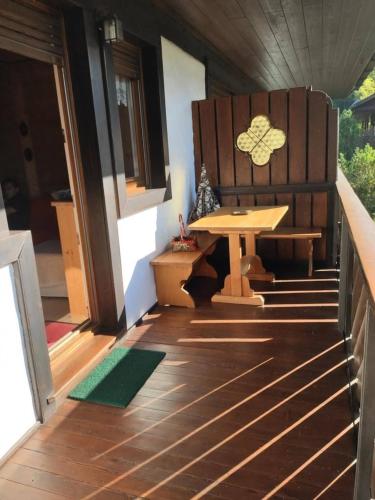 a porch with a bench and a table on a house at Villa 5 Torri in Cortina dʼAmpezzo