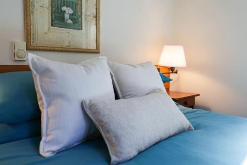 a blue bed with pillows and a picture on the wall at Family Friendly Cabin With A Firepit And A Hot Tub In Heart of Poconos in Pocono Pines
