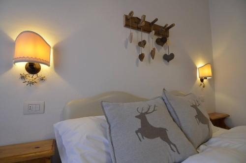 a bedroom with a bed with a deer pillow and lights at Continental 101- 4 beds in San Vito di Cadore
