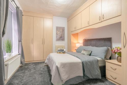 ein Schlafzimmer mit einem Bett, auf dem ein Teddybär liegt in der Unterkunft Brierfield Cottage in Brierfield